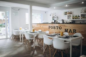 a restaurant with white tables and white chairs at Hostal Porto Mar in Salou