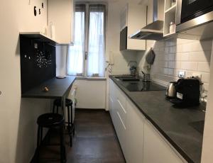 kuchnia z białymi szafkami i czarnym blatem w obiekcie Appartamento in via Licia w Rzymie