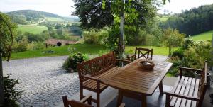 a wooden table and chairs on a patio at Ferienwohnung Lankl im Bayerischen Wald in Röhrnbach