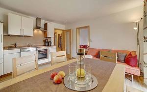 een keuken en een woonkamer met een tafel met fruit erop bij Ferienwohnung Lankl im Bayerischen Wald in Röhrnbach