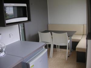 a room with a table and chairs and a tv at Camping la Croix du Sud in Saint-Tropez
