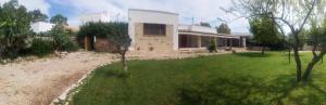 a house with a green yard in front of it at Masseria Fachechi in Nardò