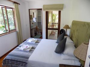 a bedroom with a large bed with towels on it at Protea Guest House in Knysna