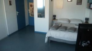 um quarto com uma cama com três almofadas em Résidence Mayol em Toulon