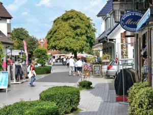 a street in a town with people walking on the sidewalk at Zum Strandkorb in Zingst