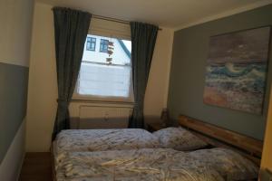 a bedroom with a bed in front of a window at Zum Strandkorb in Zingst