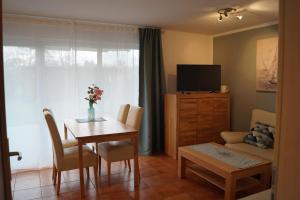a living room with a dining room table and a television at Zum Strandkorb in Zingst