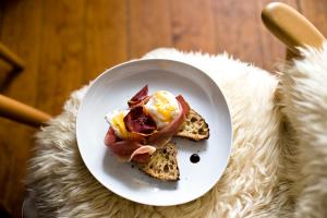 a plate with a breakfast sandwich on a table at Rosa Et Al Townhouse in Porto
