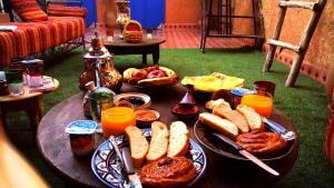 a table topped with plates of food and orange juice at Be Nomad in Marrakech