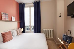 a bedroom with a large bed and a window at Le Petit Belloy in Paris
