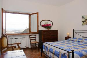 a bedroom with a bed and a dresser and a window at La Torre Nomipesciolini in San Gimignano