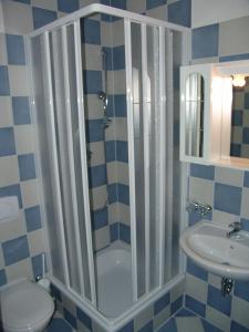 ein Bad mit einer Dusche, einem WC und einem Waschbecken in der Unterkunft Apartments Villa Seeblick in Baabe