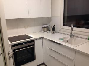 a white kitchen with a sink and a counter top at Privatzimmer an der Messe in Hannover