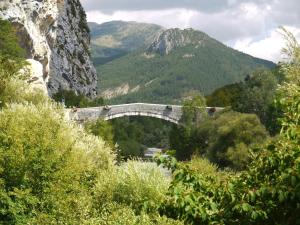 a bridge in the mountains with people on it at Résidence de l'Escoulaou in Castellane +2 photos