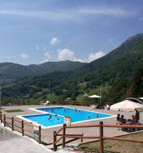 a large swimming pool with people swimming in it at Residence La Pineta in Serina
