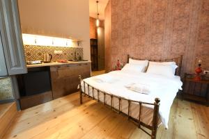a bedroom with a large bed and a kitchen at Jardin Vera in Tbilisi City