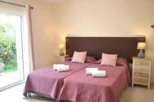 a bedroom with a large bed with pink sheets and a window at Villa on the Beach by GalanteVasques in Carvoeiro