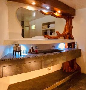 a bathroom with a large mirror and a sink at Hacienda La Rusa in Barra de Potosi