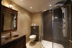 a bathroom with a sink and a shower and a toilet at Nemesis Suites in Palaios Agios Athanasios +71 photos