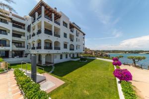 an exterior view of a large white building with a lawn at Apartment Lucia in L'Escala
