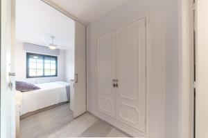 a white bedroom with a door leading to a bed at Apartment Lucia in L'Escala +12 photos
