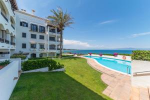 an apartment with a swimming pool next to a building at Apartment Lucia in L'Escala