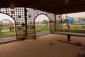 un gran pabellón con un parque infantil con tobogán en بوابة الرمال السياحية Tourism sands gate en Al Wāşil