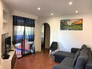 Una sala de estar con un sofá y un televisor. en Bungalow Punta Marina, en Torrevieja