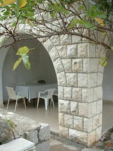a stone archway with a table and chairs in a building at Apartments and Rooms Artemida in Dubrovnik