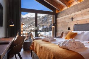 a bedroom with a bed with a view of a mountain at 22 Summits Boutique Hotel in Zermatt