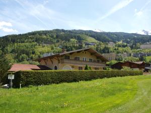 ein Haus auf einem Hügel mit einem grünen Feld in der Unterkunft Golfappartements in Bad Gastein