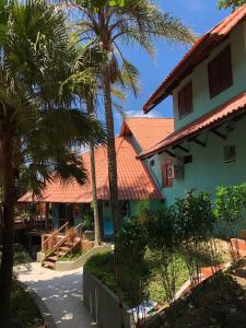 una casa con palmeras delante en Pousada Reserva do Tombo Lounge Hostel en Guarujá