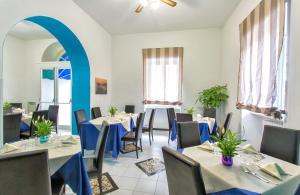 um restaurante com mesas e cadeiras e um arco azul em Hotel Terme Miramonte e Mare em Ischia