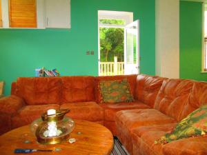 sala de estar con sofá de cuero marrón y mesa de madera en Weston Manor en Freshwater