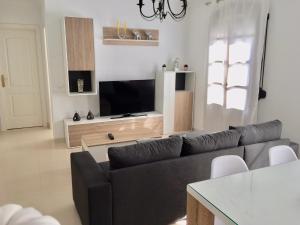 a living room with a couch and a flat screen tv at Apartamento Pasaje Ronda Centro in Ronda