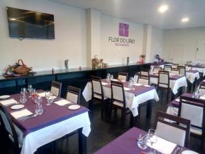 a dining room with tables and chairs in a restaurant at Hotel Monte Lírio in Espinho