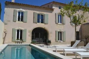 a villa with a swimming pool in front of a house at Mas À l'Improviste in Saint-Rémy-de-Provence