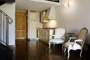 - une cuisine avec deux chaises blanches et une table dans l'établissement Assia Spa, à Fucecchio