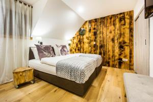 een slaapkamer met een bed en een houten wand bij Hotel Pok Garni in Brezovica