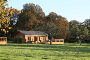 a house sitting in the middle of a field at The Orchard Bramble Lodge in Hadleigh