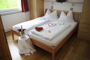 una camera da letto con un letto con lenzuola bianche e un vaso di Flößerdorf Großraming a Grossraming