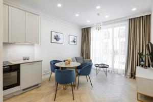 a kitchen and living room with a table and chairs at Aula apartments in Vilnius