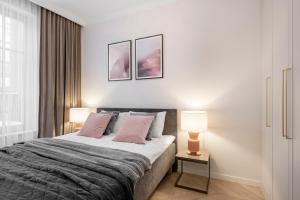 a bedroom with a large bed with two lamps at Aula apartments in Vilnius