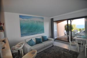 - un salon avec un canapé blanc et une grande fenêtre dans l'établissement Appartement 1 chambre vue mer au Clos de la Madrague, à Sainte-Maxime