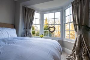 a bedroom with a bed and a large window at Court House Apartment in Cheltenham