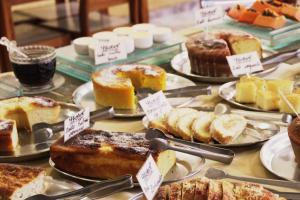 a display of different types of cakes and pastries at Hotel São Lucas in Alfenas