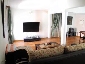 sala de estar con sofá y TV en Casa de alquiler San Juan en San Juan