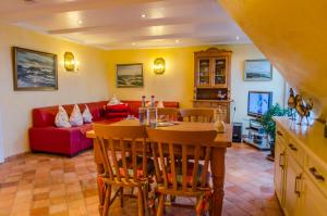 a living room with a table and a red couch at Haus Seelord, Whg. Bootsmann in Braderup