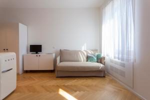 a white living room with a couch and a television at Residence Itaca in Castellammare del Golfo