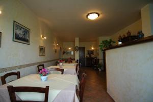 ein Restaurant mit Tischen und Stühlen mit Blumen darauf in der Unterkunft Agriturismo San Vincenzo in Sovana